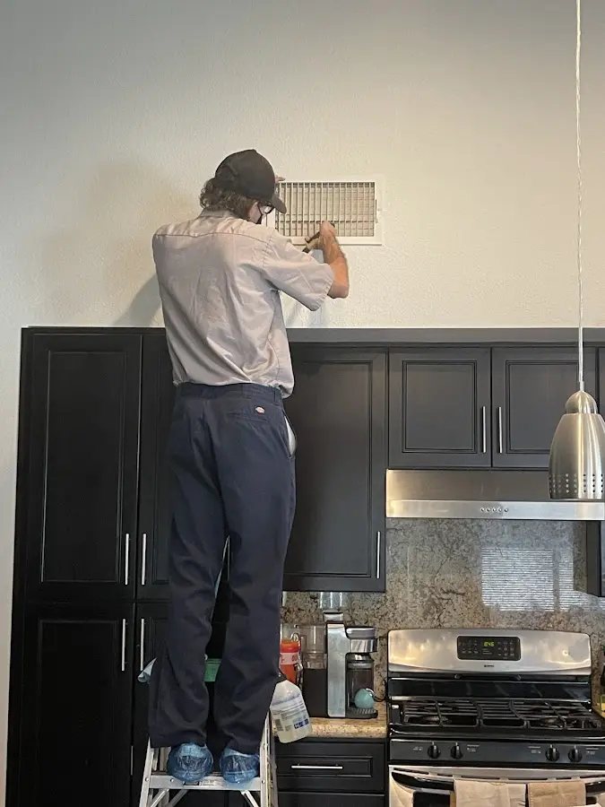 Technician inspecting an air vent during HVAC service in Cutler Bay